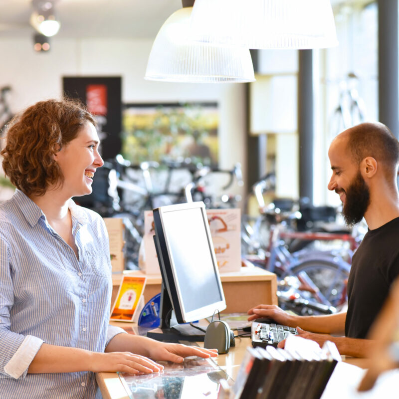 Lifestyle Shopping - junge Frau kauft in einem Fahrradladen ein, Beratung durch Verkäufer Lifestyle Shopping - junge Frau kauft in einem Fahrradladen ein, Beratung durch Verkäufer